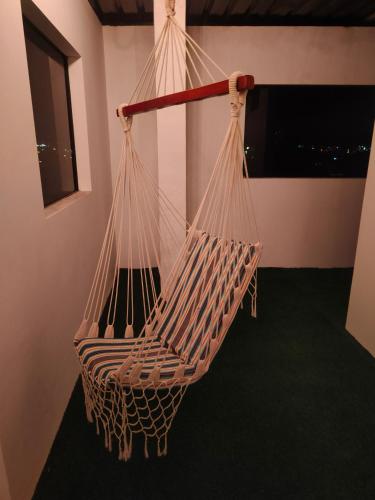 a hammock in a room with a green carpet at Roca Luminosa, Cine in Riobamba