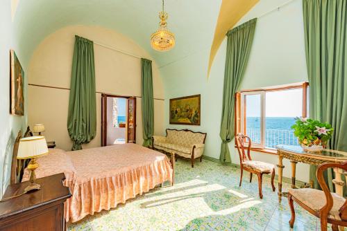 a bedroom with a bed and a couch and a window at Villa Costa degli Dei in Furore