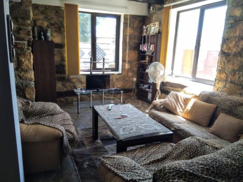 Una sala de estar con dos sofás y una mesa. en Guest House Poli, en Levski