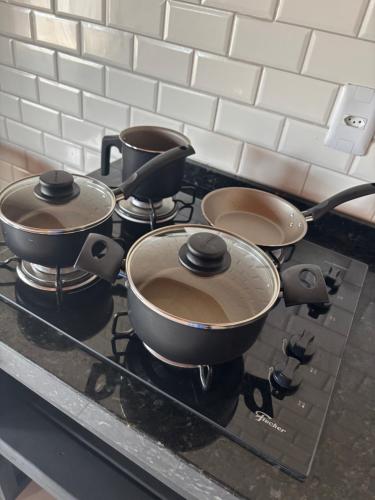 a group of pots and pans on a stove at Pousada Encosta das Oliveiras in Imbituba