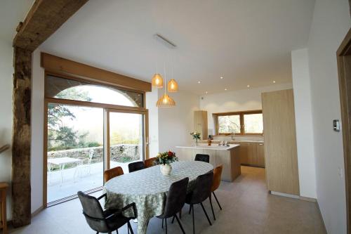 une cuisine et une salle à manger avec une table et des chaises dans l'établissement Logis du Château de Beccon- Entre Annecy et Genève, à Cruseilles