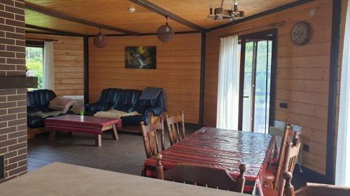 un porche cubierto con mesa y sofá en Котедж “Гуркало", en Korchin