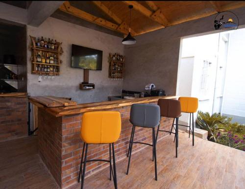 a bar with four chairs and a counter in a room at Iwandaa Lodge And Apartments in Sokon