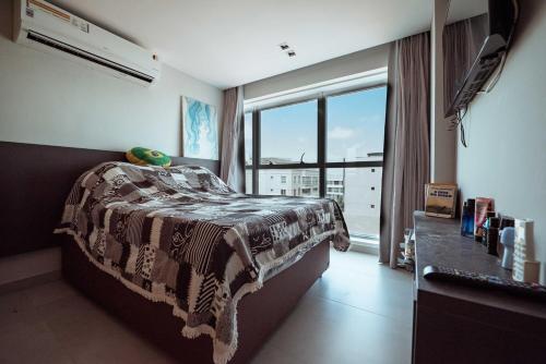 a bedroom with a bed and a large window at Apto c otima localizacao a 120m da praia de Tambau in Tambaú
