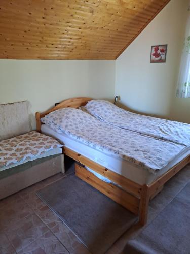 two twin beds in a room with wooden ceilings at BALATONHEGYVIDÉKI APARTMAN in Balatonederics