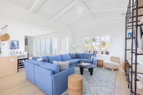 a living room with a blue couch and a table at Brand New & Private Pool - Palmgale House in Key West
