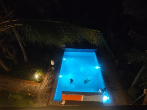 an overhead view of a swimming pool at night at PV Cottages - Serenity Beach in Puducherry
