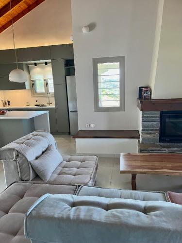 a living room with two couches and a kitchen at Gianna's Guesthouse & Cave Studio in Pylos