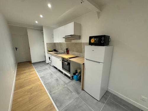 une petite cuisine avec un réfrigérateur et un évier dans l'établissement Apt Neuf - 1 Chambre Stade de France, à Saint-Denis