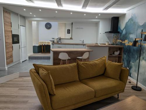 un salon avec un canapé et une cuisine dans l'établissement Maison chaleureuse au cœur du centre ville, à Pornic