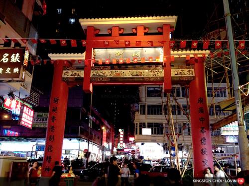 a red sign with writing on a city street at Metacity MK 名廸旺角 in Hong Kong