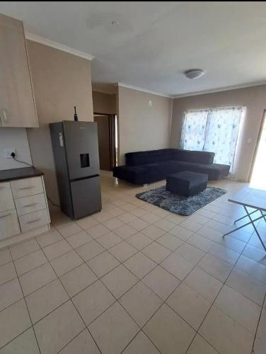 a living room with a couch and a refrigerator at Ocean View Cottage in Swakopmund