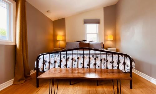 a bedroom with a bed with a bench next to a window at KingstonStays The Neighbourhood, Expansive loft, free parking in Kingston
