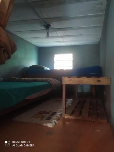 a room with a bed and a table in it at Casa meu canto in Lençóis