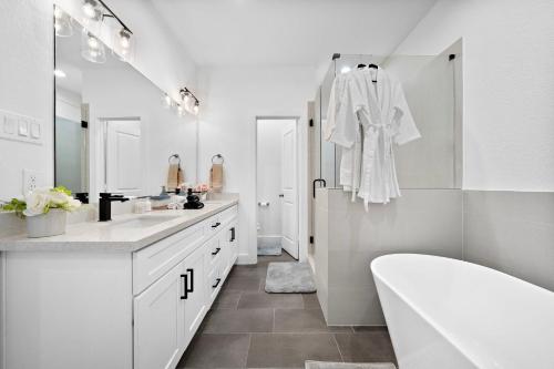 a white bathroom with a tub and a sink at Cozy Home Near MedCenter, Uptown, & Downtown in Houston
