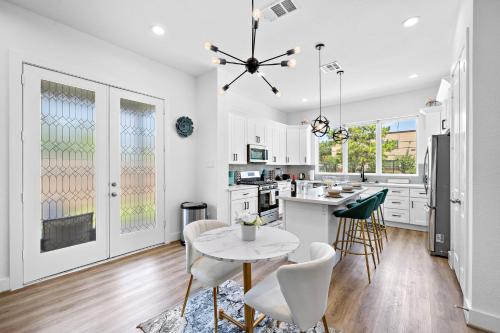 a kitchen with white cabinets and a table and chairs at Cozy Home Near MedCenter, Uptown, & Downtown in Houston
