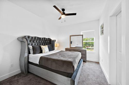 a bedroom with a bed and a ceiling fan at Cozy Home Near MedCenter, Uptown, & Downtown in Houston