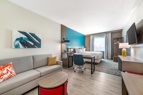 a living room with a couch and a bedroom at Comfort Suites Fort Myers East I-75 in Fort Myers