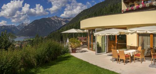 a hotel with a patio with a view of the mountains at Naturhotel Alpenblick in Maurach