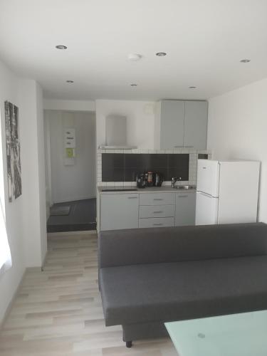  La cuisine est équipée de placards blancs et d'un réfrigérateur. dans l'établissement appartement résidentiel 2 pièces, à Pierrefitte-sur-Seine