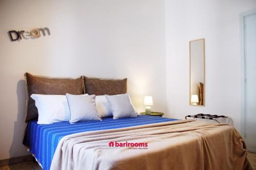 1 dormitorio con 1 cama con sábanas azules y almohadas blancas en BARI ROOMS Central Station, en Bari