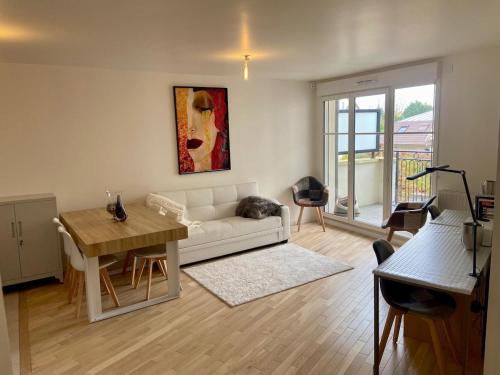 un salon avec un canapé blanc et une table dans l'établissement Beautiful modern apartment near Paris, à Clamart