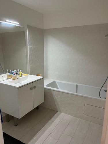 une salle de bain blanche avec une baignoire et un lavabo dans l'établissement Beautiful modern apartment near Paris, à Clamart