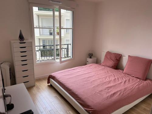 - une chambre avec un lit rose et une fenêtre dans l'établissement Beautiful modern apartment near Paris, à Clamart