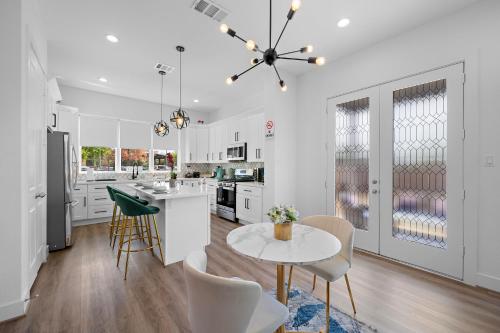 a kitchen with white cabinets and a table and chairs at Luxury Home Near Med Center, Uptown & Downtown in Houston