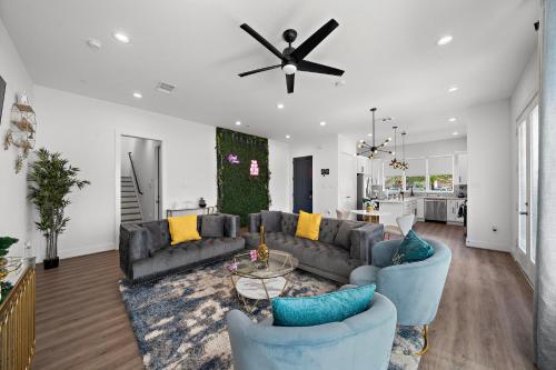 a living room with couches and a ceiling fan at Luxury Home Near Med Center, Uptown & Downtown in Houston