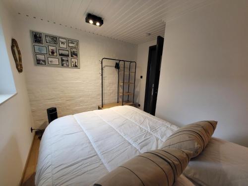a bedroom with a white bed in a room at O2Lienne, maison de campagne de charme in Lierneux