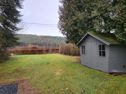 a small shed sitting in the middle of a yard at O2Lienne, maison de campagne de charme in Lierneux