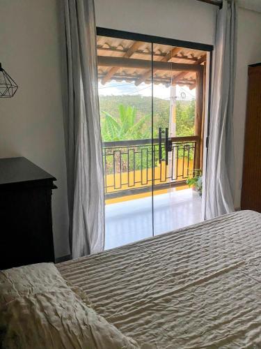 a bedroom with a bed and a view of a balcony at Suíte Lençóis in Lençóis