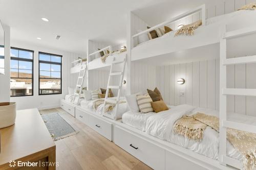 a white bedroom with two beds and a desk at Deja Blue at Desert Color by Ember Stays in St. George