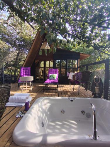 a bath tub sitting on top of a wooden deck at Cabaña de madera romántica y privada in Tepetlapa