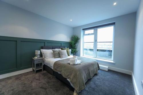 una camera da letto con un letto grande e una finestra di Penthouse with Hot Tub by Cambridge Station a Cambridge