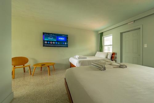 a room with two beds and a tv on the wall at Tropical Breeze in Clearwater Beach