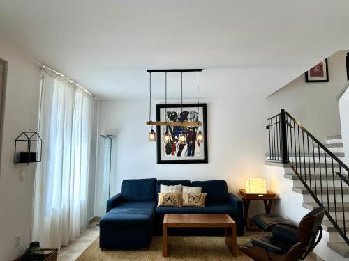 a living room with a blue couch and a staircase at 3Bedrooms-5 min Downtown-Wifi-Pool-Jacuzzi-Parking in San Miguel de Allende