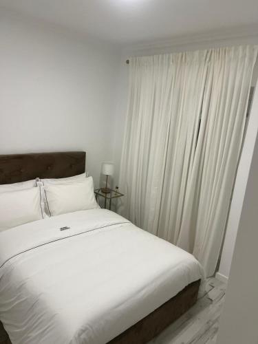 a bedroom with a bed with white sheets and a window at Amadora Flat 4 in Amadora