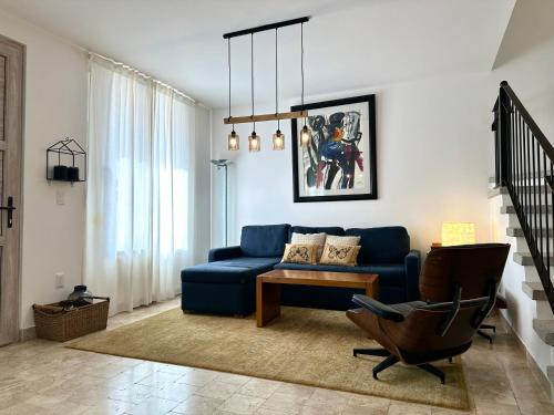 a living room with a blue couch and a chair at 3Bedrooms-5 min Downtown-Wifi-Pool-Jacuzzi-Parking in San Miguel de Allende