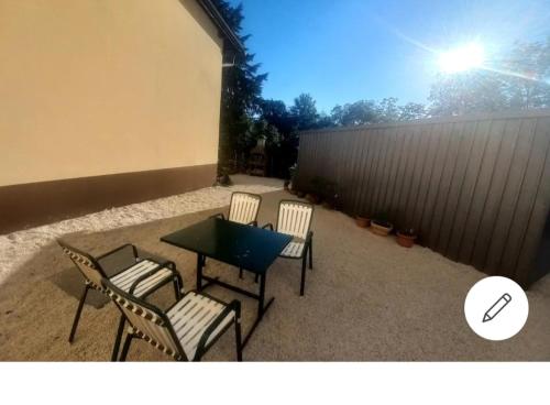 a patio with four chairs and a table and a fence at Ferienwohnung Katharina in Steinbach am Attersee