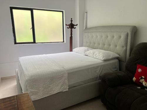 a bedroom with a bed and a window and a chair at Finca Bellavista in Villeta