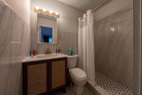 a bathroom with a toilet and a sink and a mirror at Tropical Breeze in Clearwater Beach
