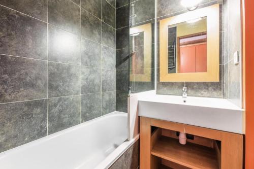 une salle de bain avec un lavabo, une baignoire et un miroir dans l'établissement Résidence L'Ours Blanc - maeva Home - Studio 4 Personnes Sélection MAE-8862, à Huez