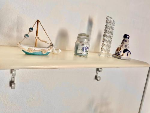 a shelf with a toy scale and a jar on it at Appartamento Valencia 50 meters from the shore in Torre Ovo