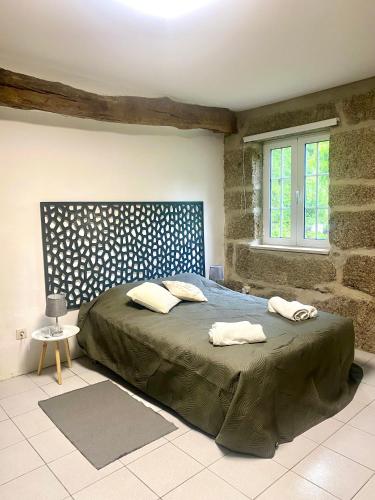 a bedroom with a bed with two towels on it at Quinta de Ribas in Amarante