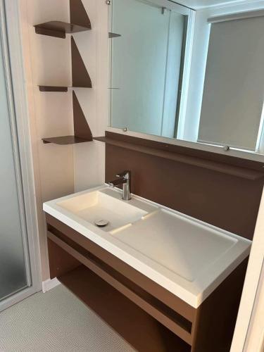 une salle de bain avec un lavabo et un miroir dans l'établissement Bungalow à Nice, à Cagnes-sur-Mer