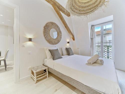 une chambre blanche avec un lit et un miroir dans l'établissement Hyper Centre - Charming duplex - Luxury - Reversible air conditioning - 10 mins from Place MASSENA, à Nice