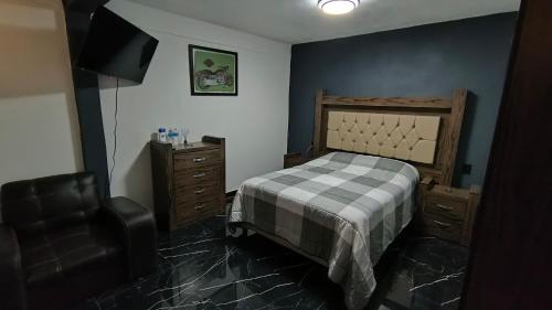 a bedroom with a bed and a chair and a television at Casa Mi viejo San Juan in San Juan Teotihuacán
