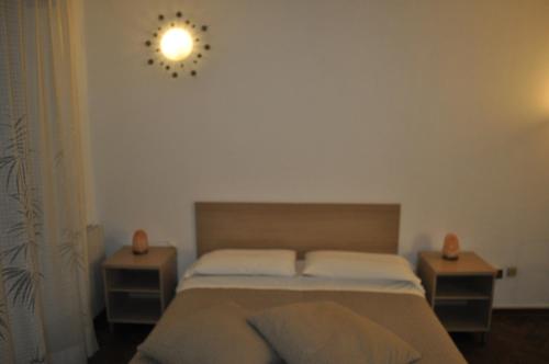 a bedroom with a bed with two nightstands and a clock at Affittacamere Elisa in Pisa